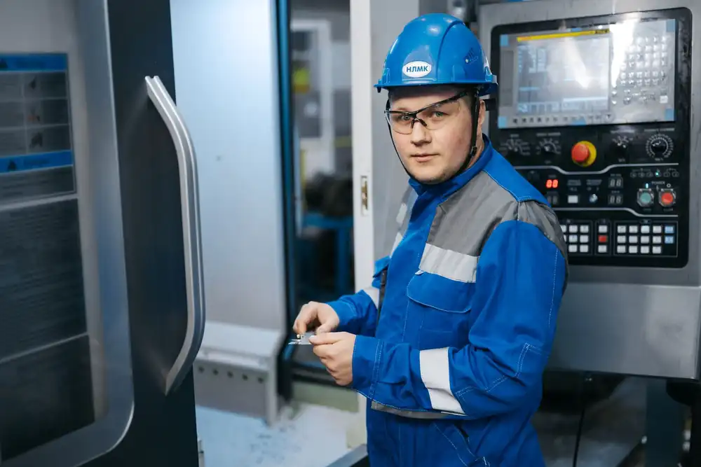 Industrial engineer operating a CNC machine in a manufacturing workshop